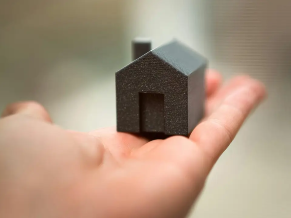 A small figurine home in the palm of someone's hand.