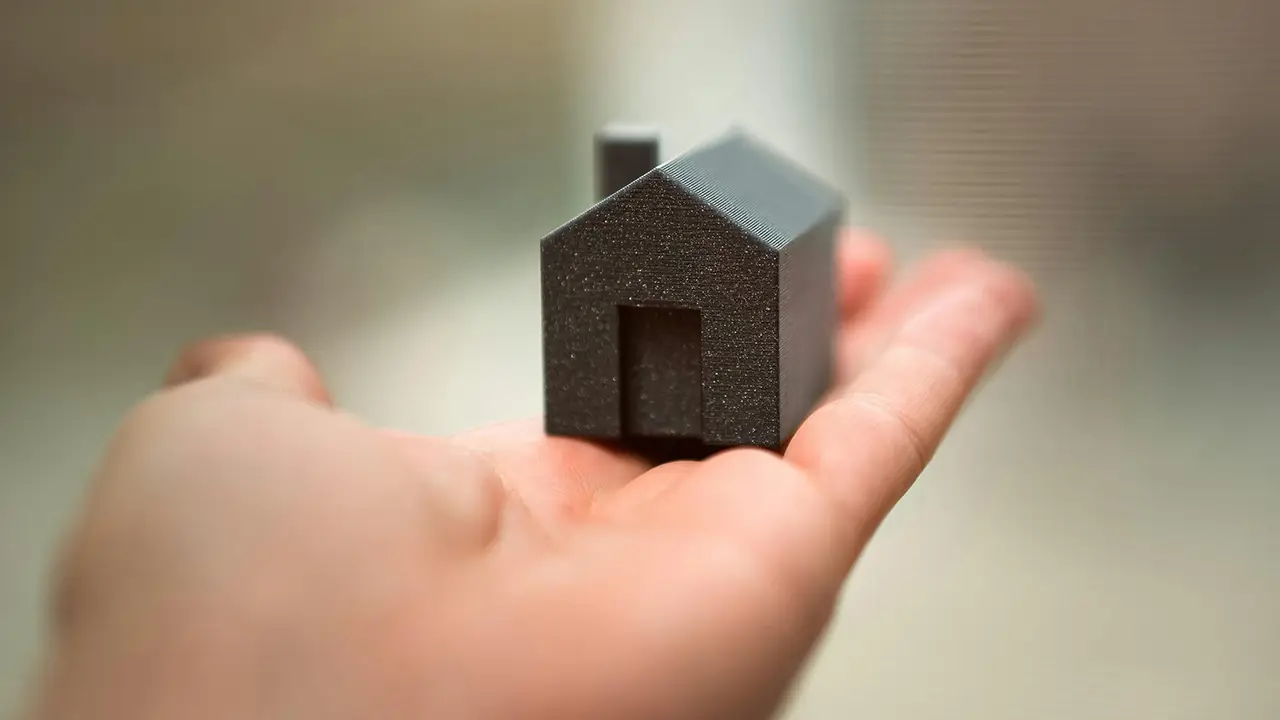 A small figurine home in the palm of someone's hand.